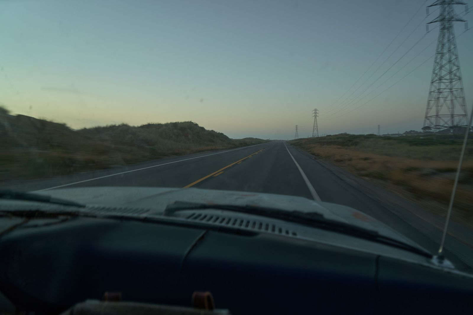 A car on a long highway at dusk, typical of the 401 run from Toronto to Detroit airport