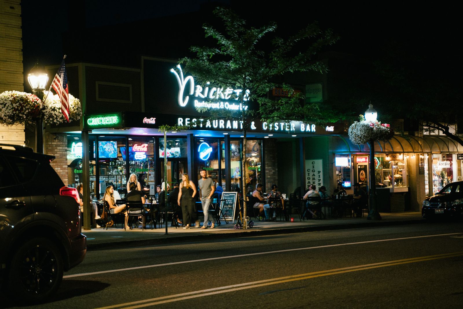 Restaurants lit up at night on a busy city street in Toronto