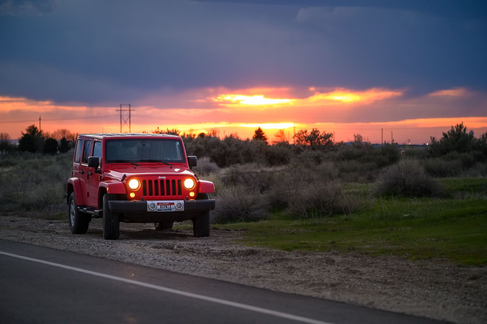 A black SUV on a highway at dusk