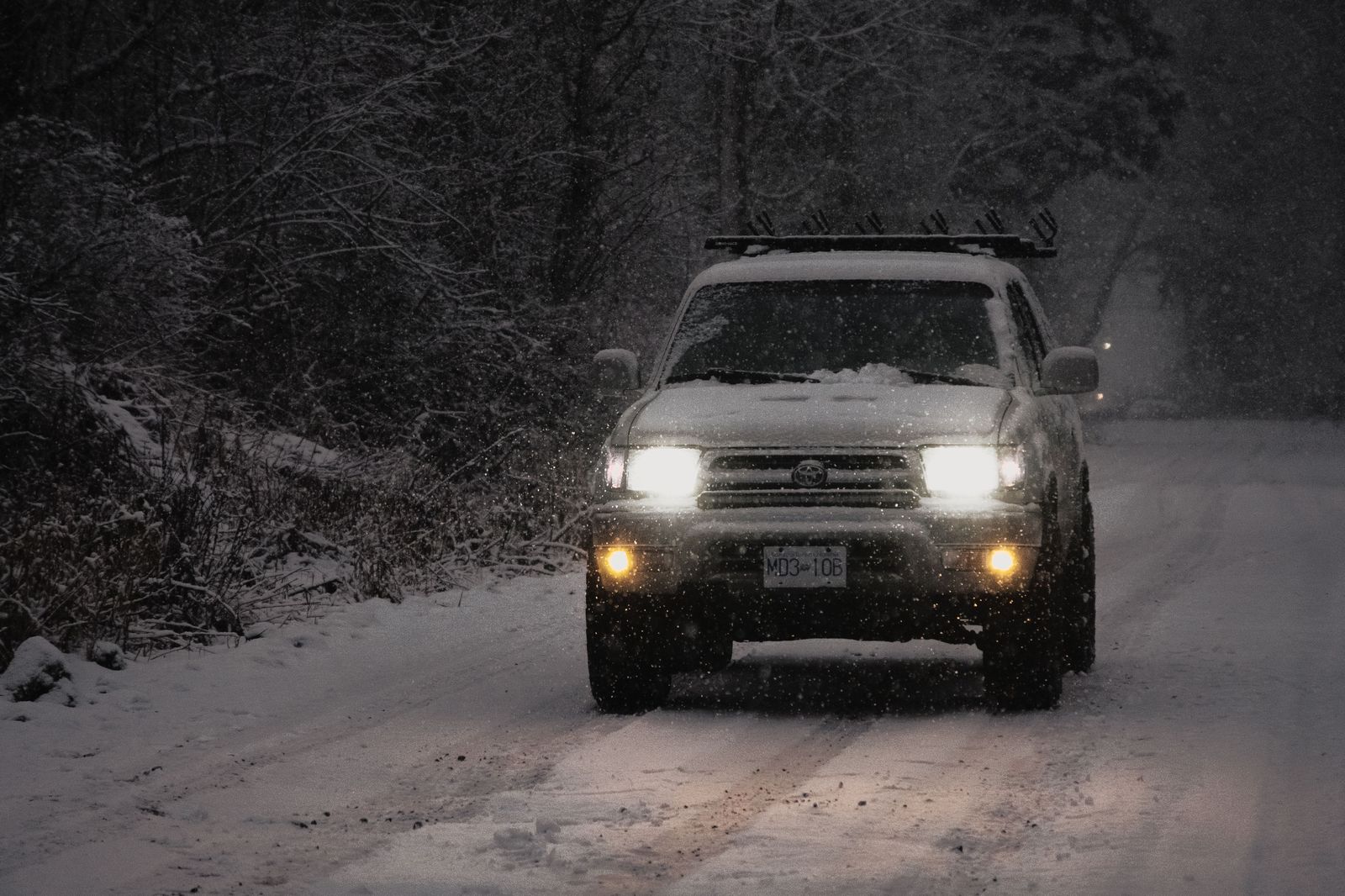 Black SUV on a snowy Toronto street at night