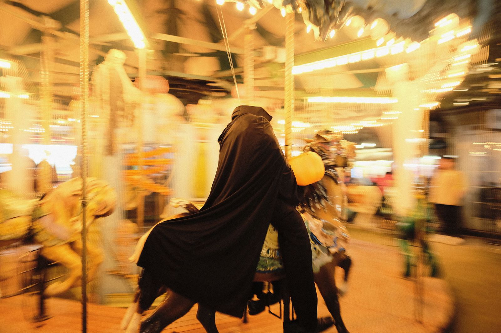 Amusement park rides lit up at night during the autumn Halloween season