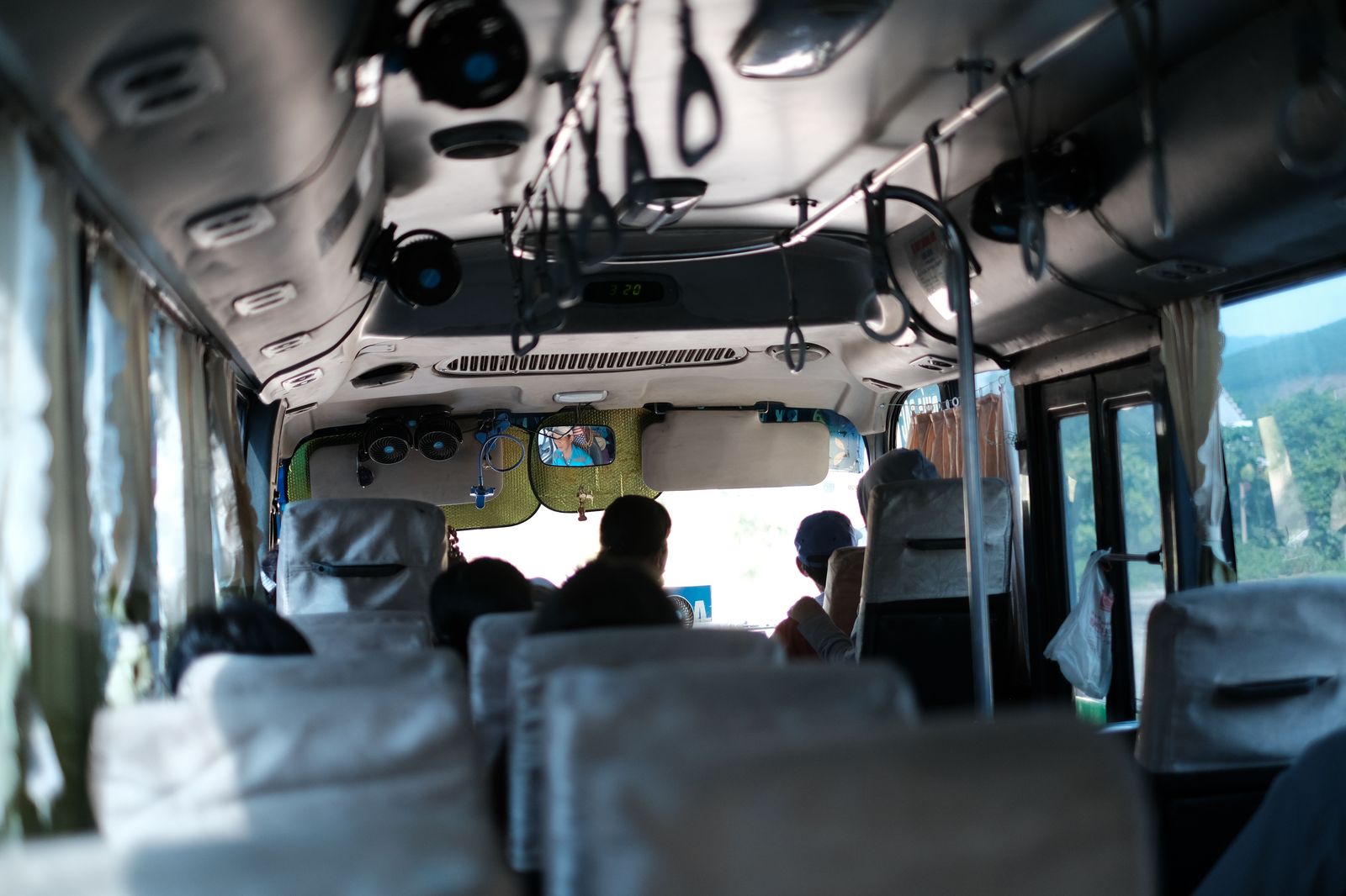 Passengers with rolling suitcases on board a city bus heading to the airport