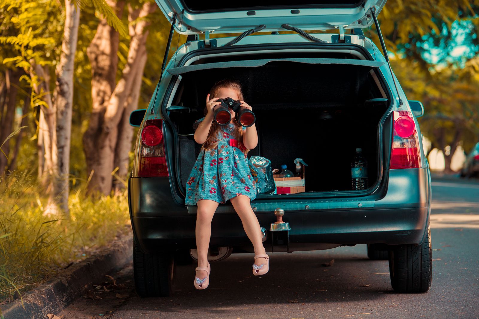 A family loading suitcases into the back of a car before an airport run