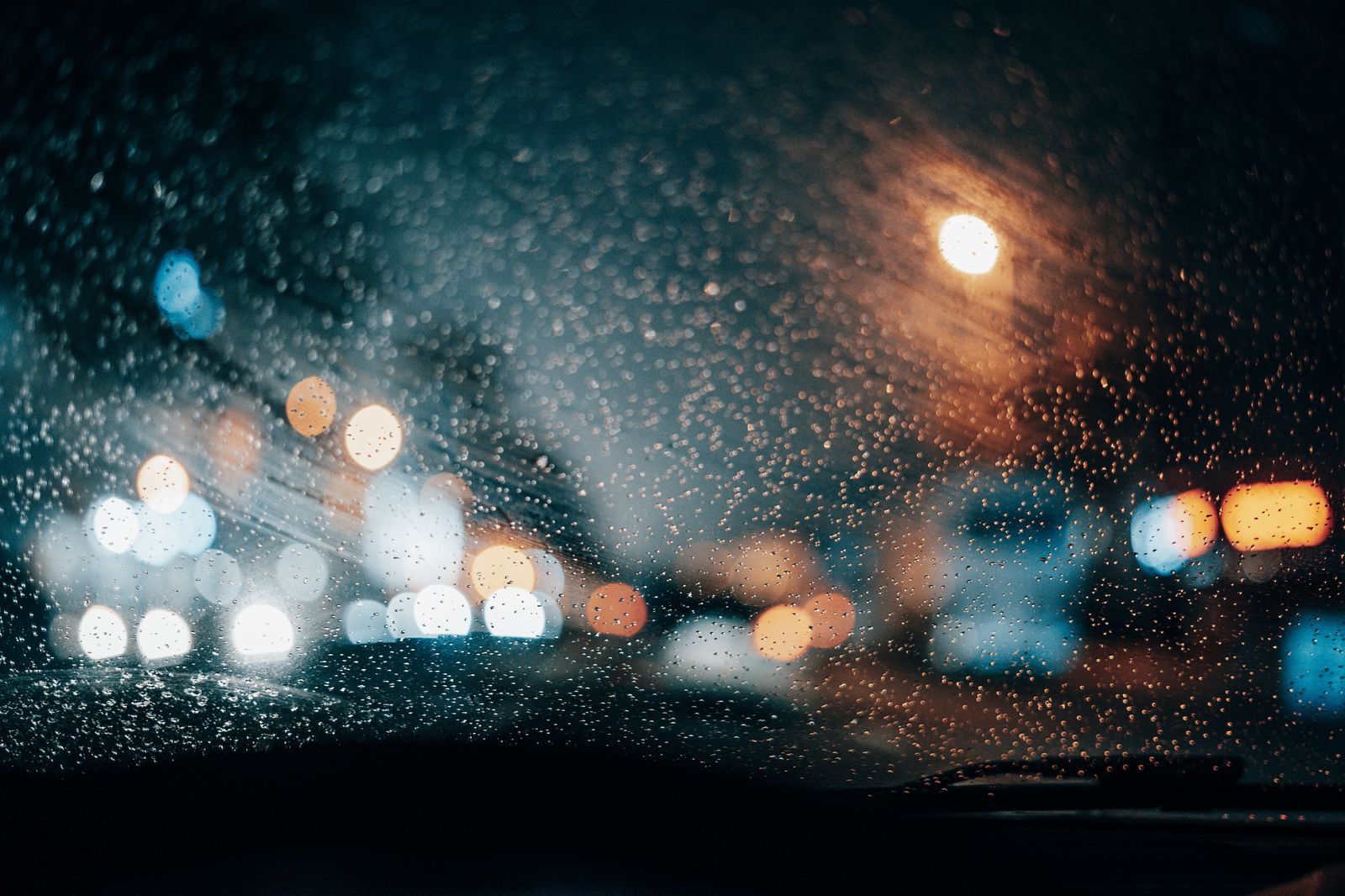 City lights seen through the window of a car moving through downtown at night