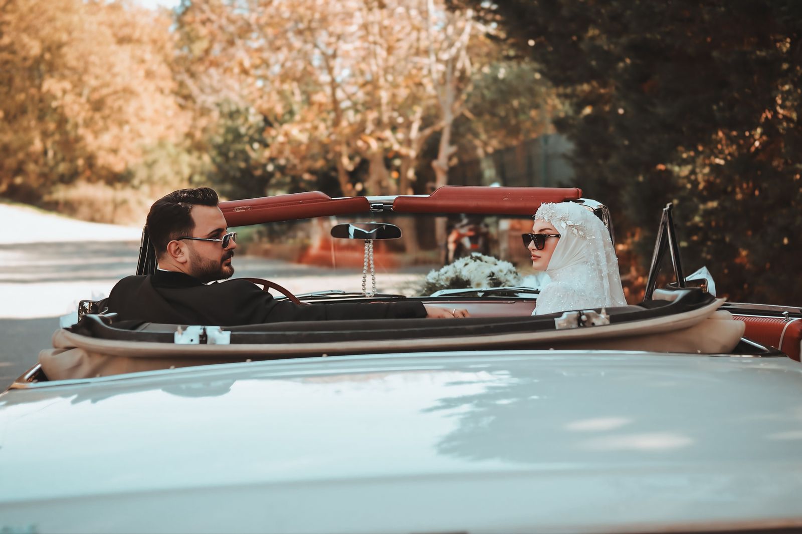 A wedding couple stepping out of a chauffeured car at a lakeside venue