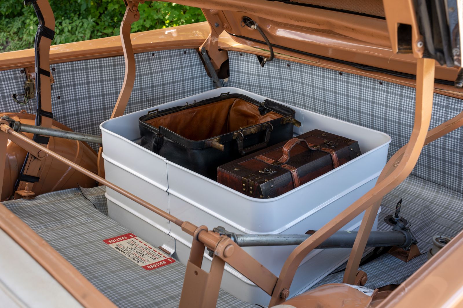 A stroller and suitcases being loaded into the trunk of an SUV for a family airport run