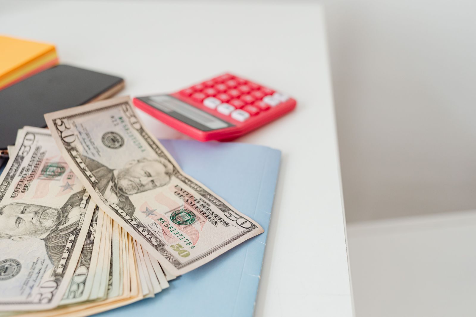 A notebook and calculator on a desk, planning the cost of a trip
