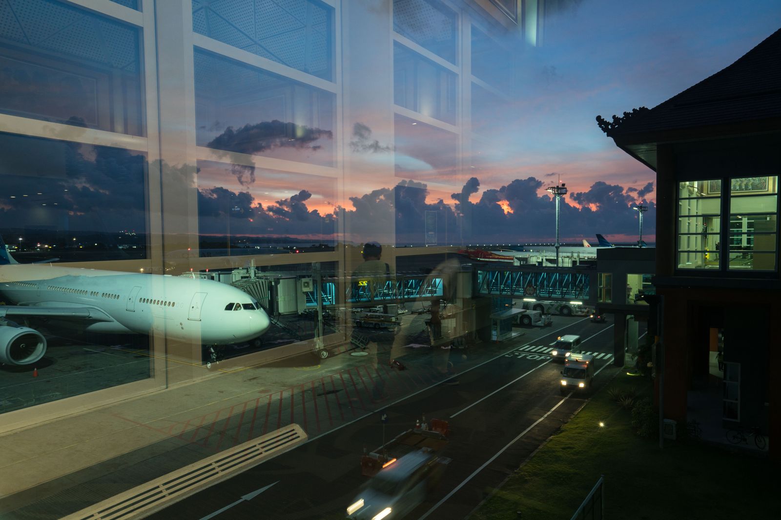 An airport terminal curb at night, where a booked car waits after a late landing