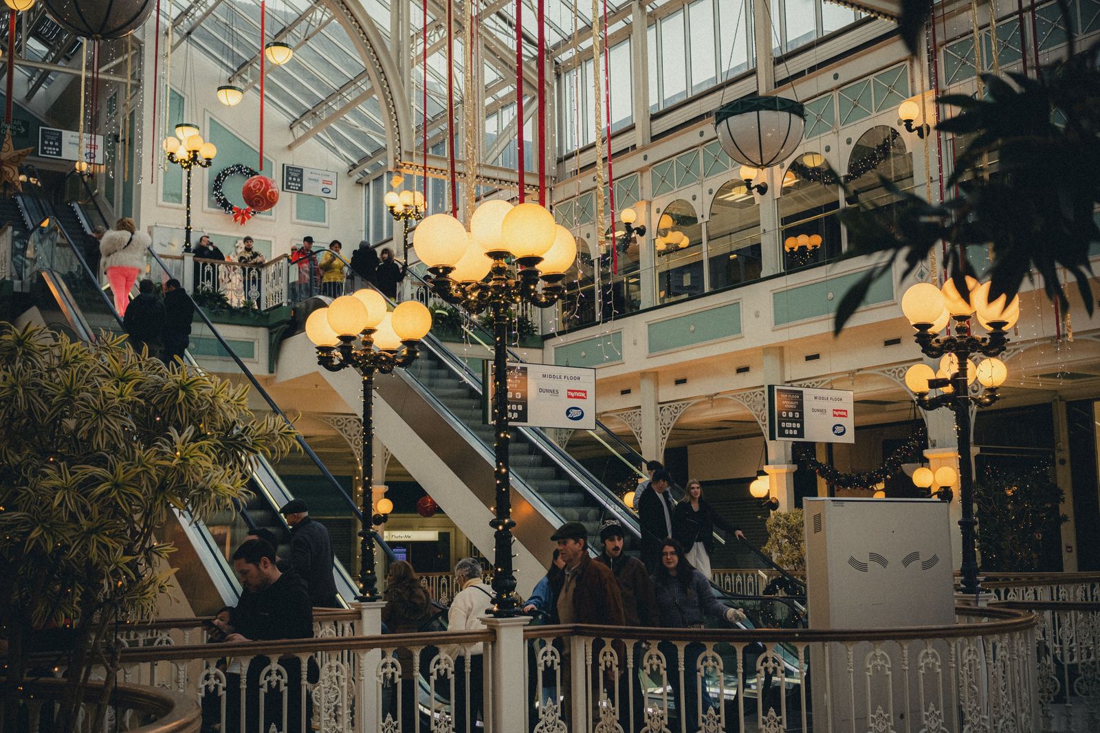 A busy shopping mall atrium with shoppers and skylights