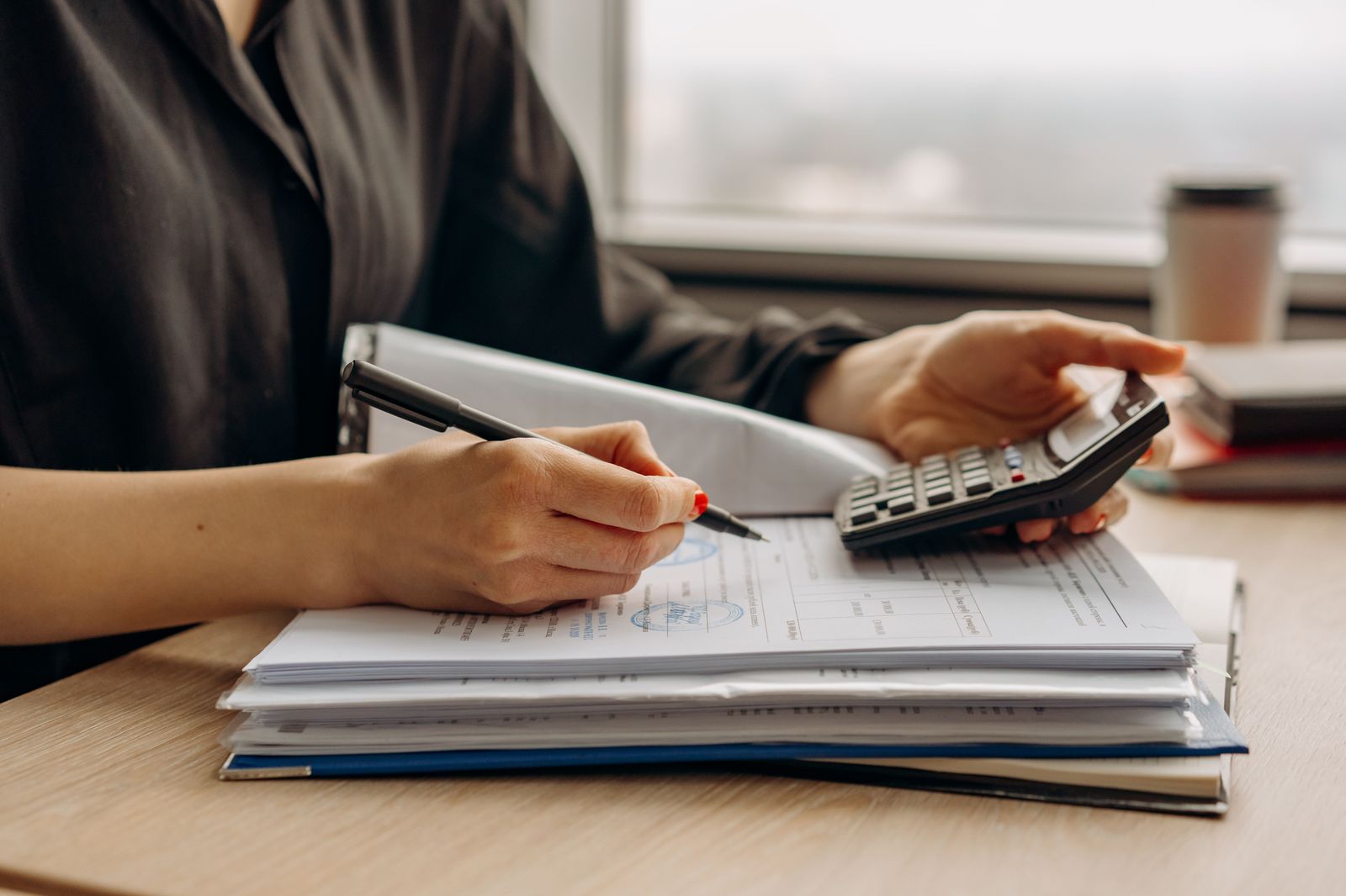 An invoice and calculator on a desk, comparing the line items on two limousine quotes