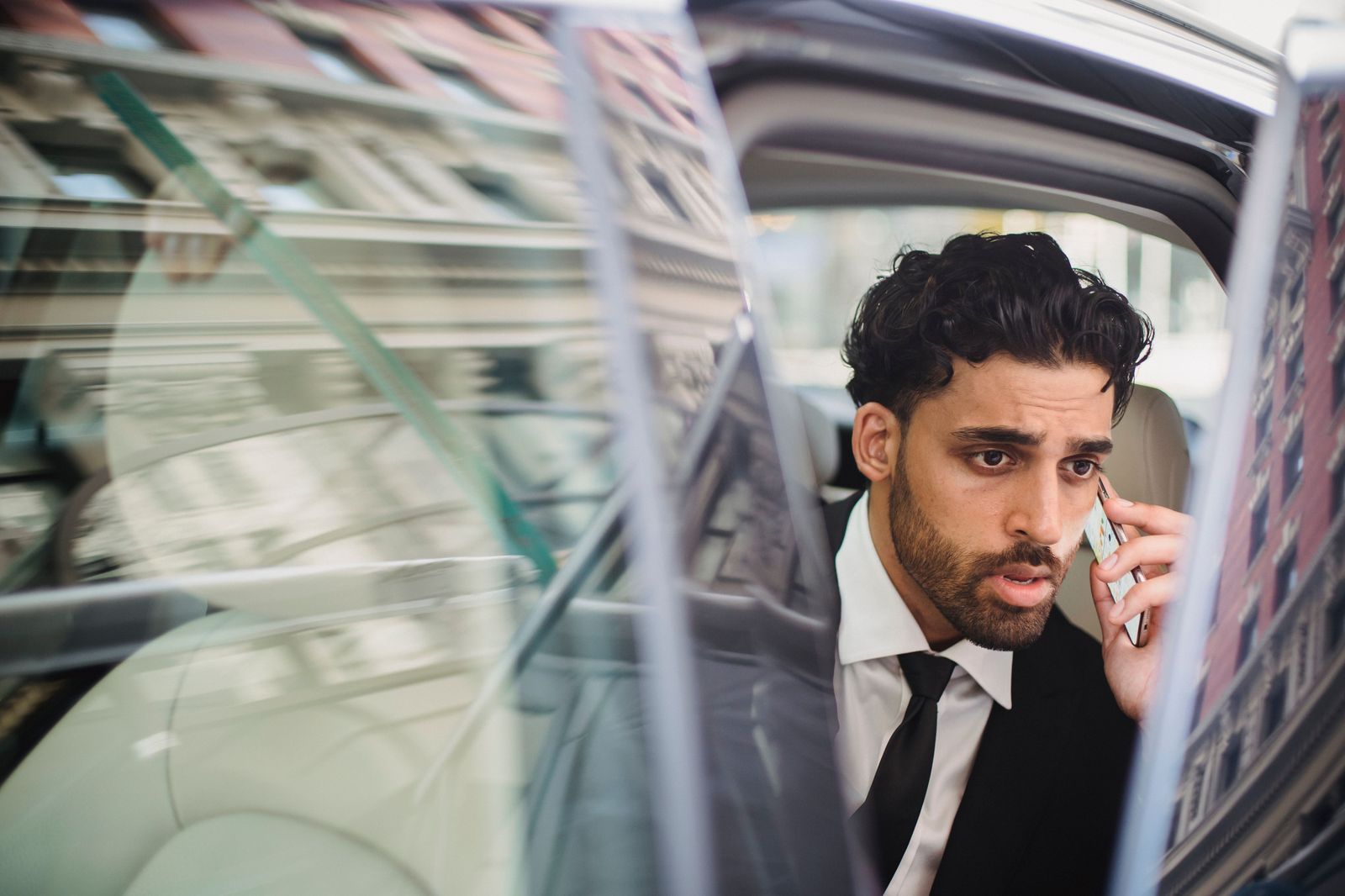 A business traveller checking a phone while waiting for a car