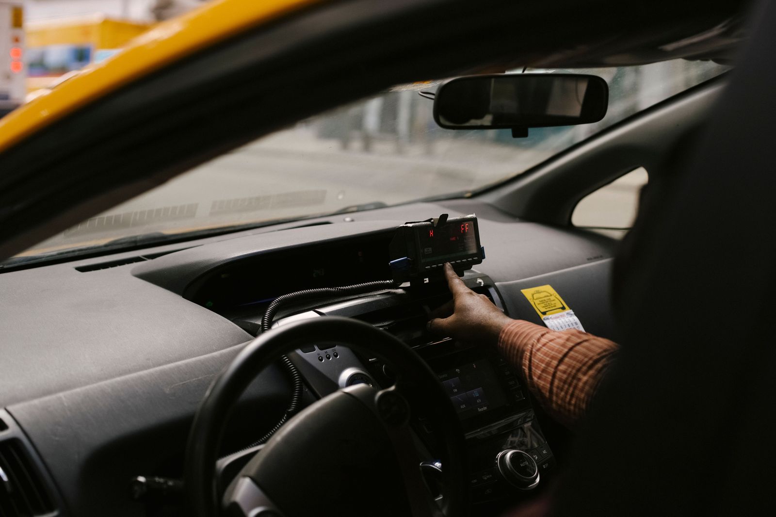 The dashboard of a taxi with a fare meter running