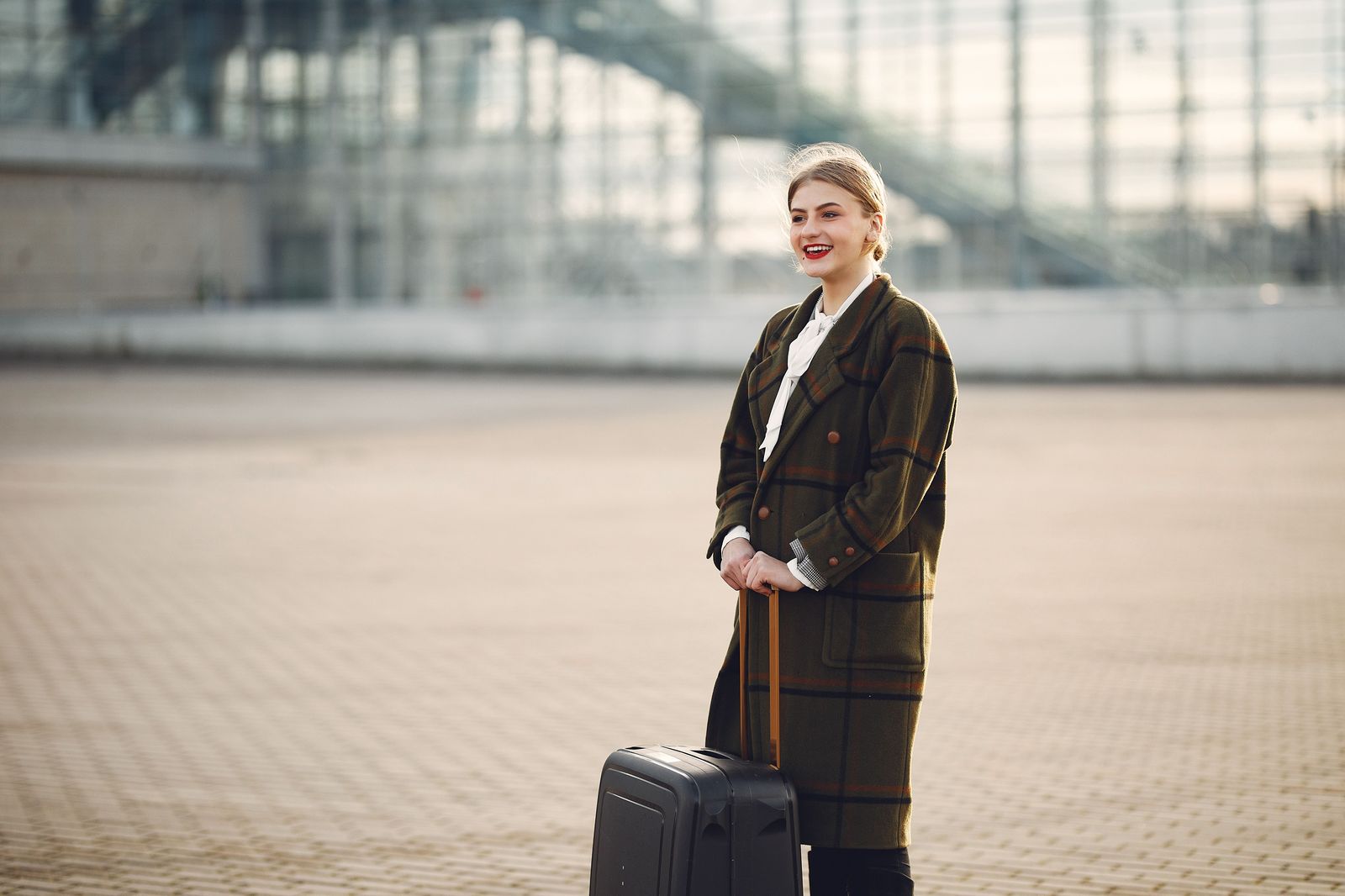 A traveller with a suitcase walking through an airport arrivals hall