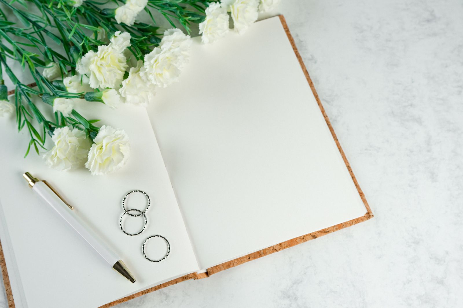 A wedding planner's notebook with a timeline beside a bouquet of flowers
