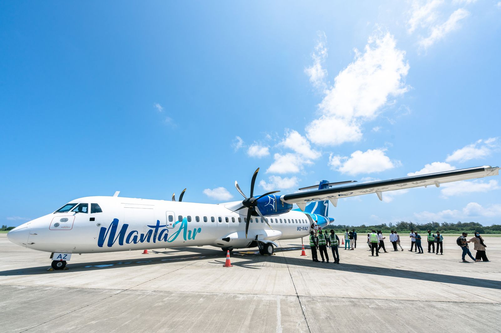 Passengers boarding a turboprop aircraft by the forward stairs