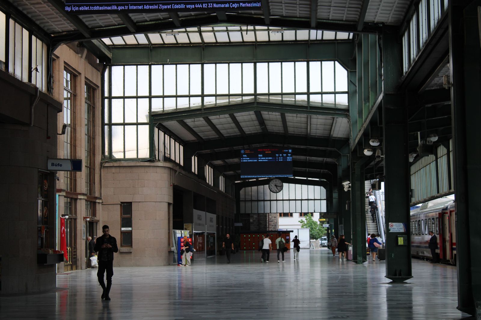 Travellers crossing a grand railway station hall with luggage