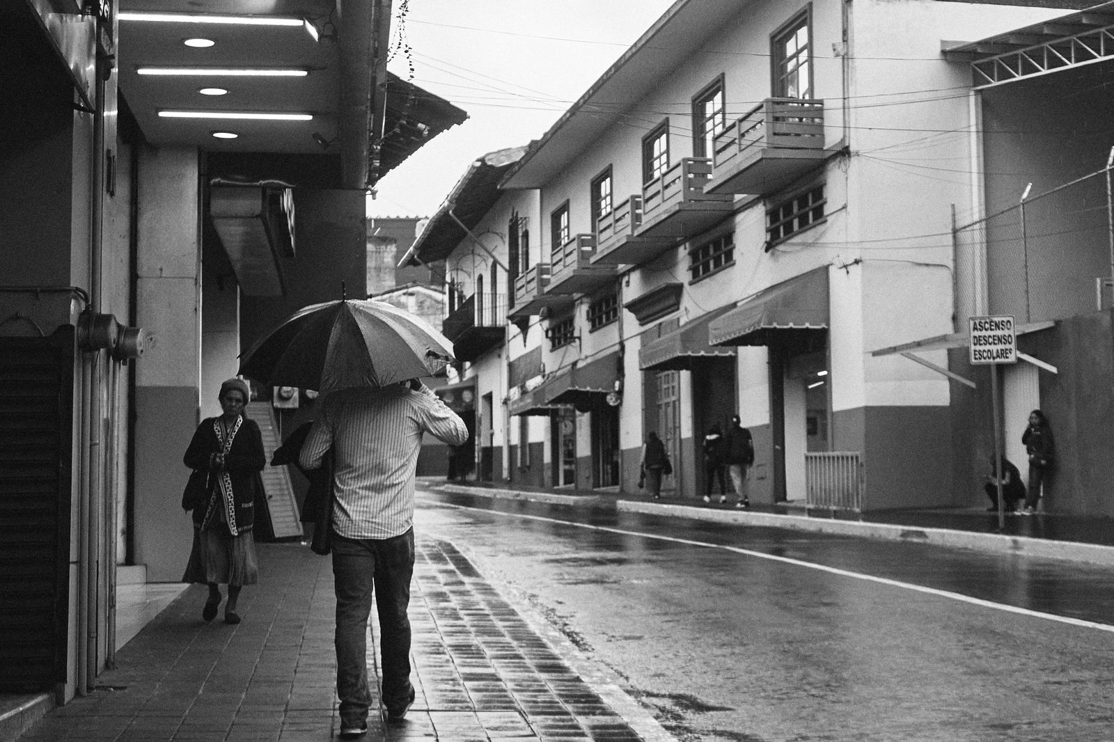 Pedestrians with umbrellas on a rainy city street, the day to take the shuttle instead