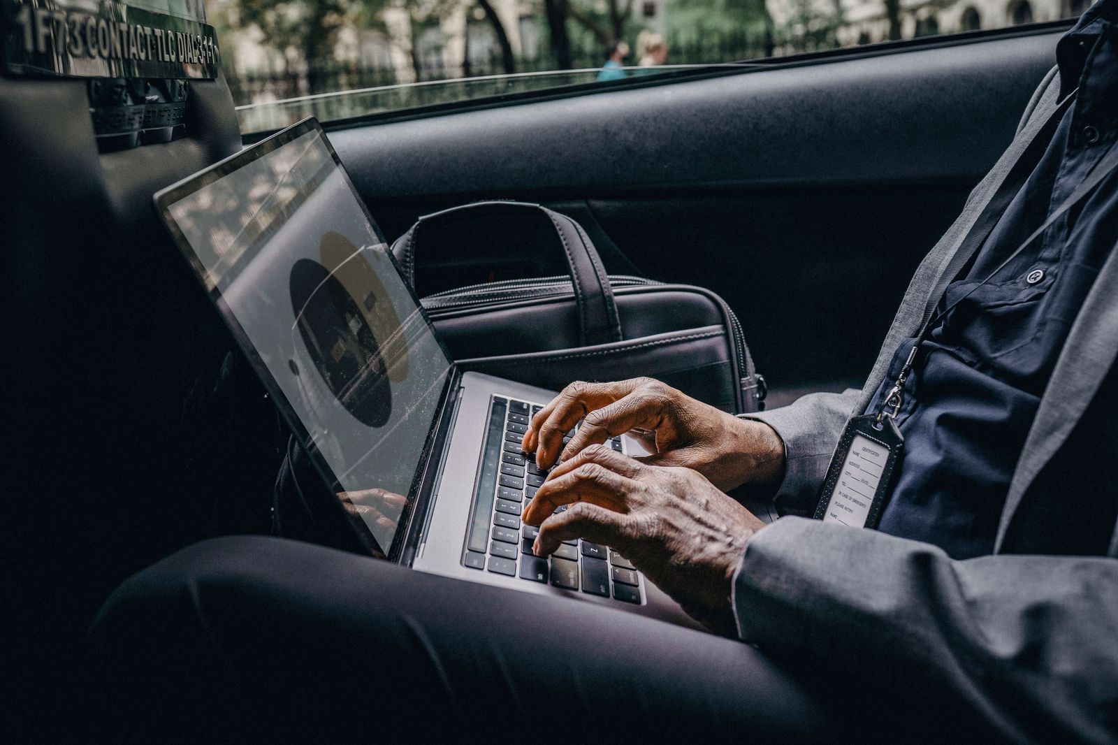 A traveller working in the back seat on the way from Pearson to the office