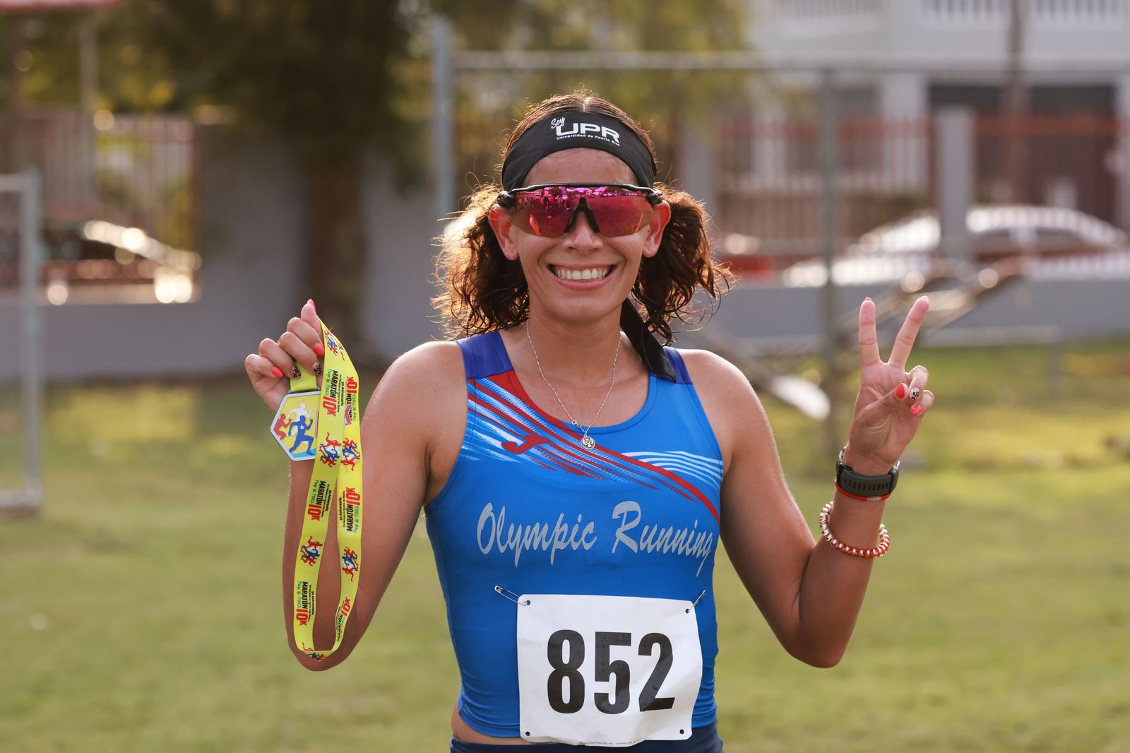 A finisher with a medal waits for the car after the race