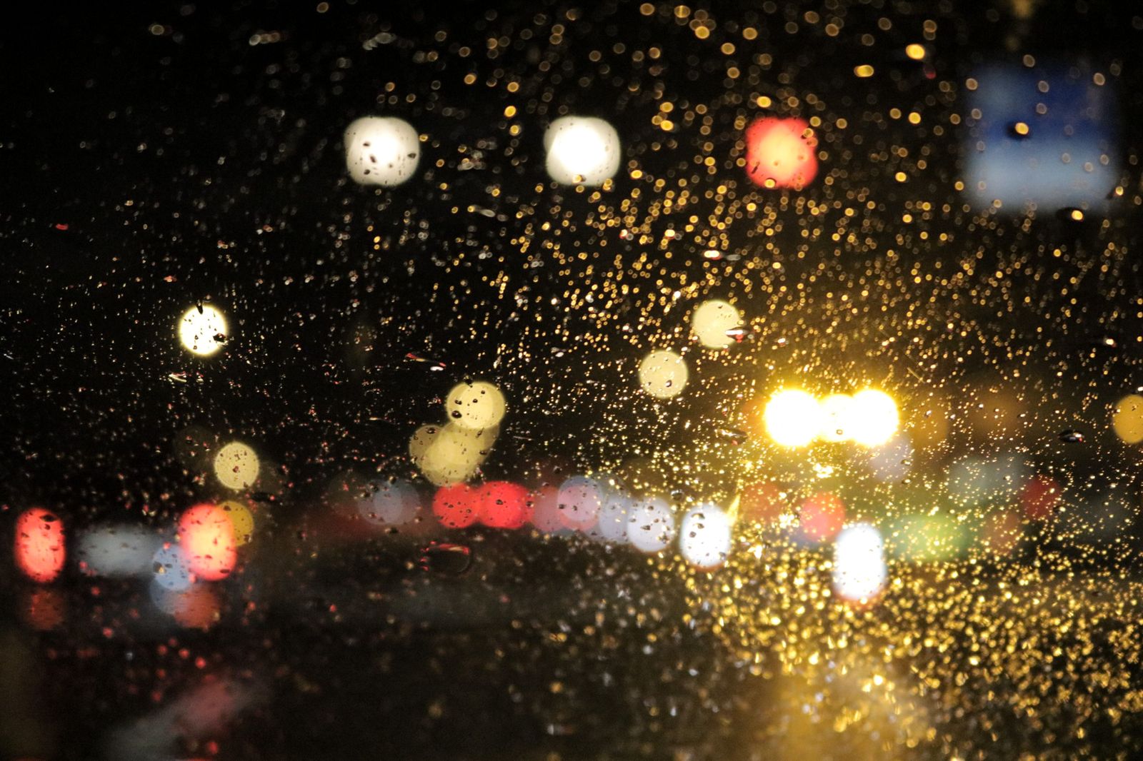 A chauffeur-driven car waiting under city lights late at night