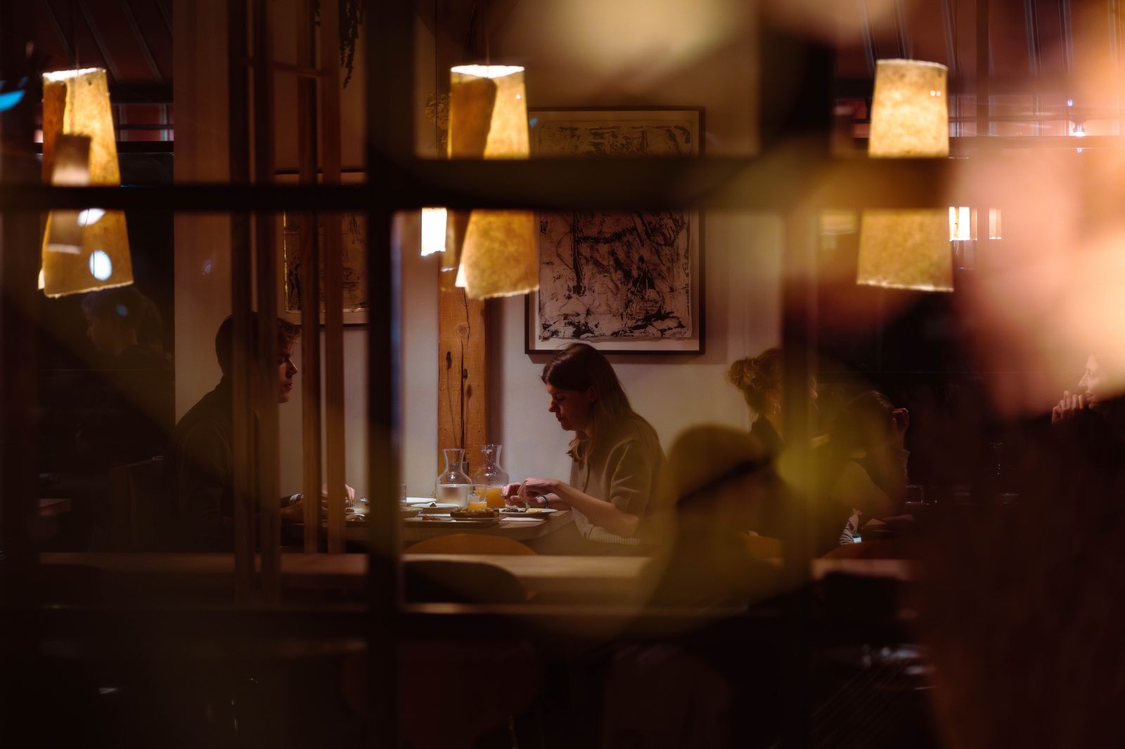 A candlelit table for two by a window overlooking the city
