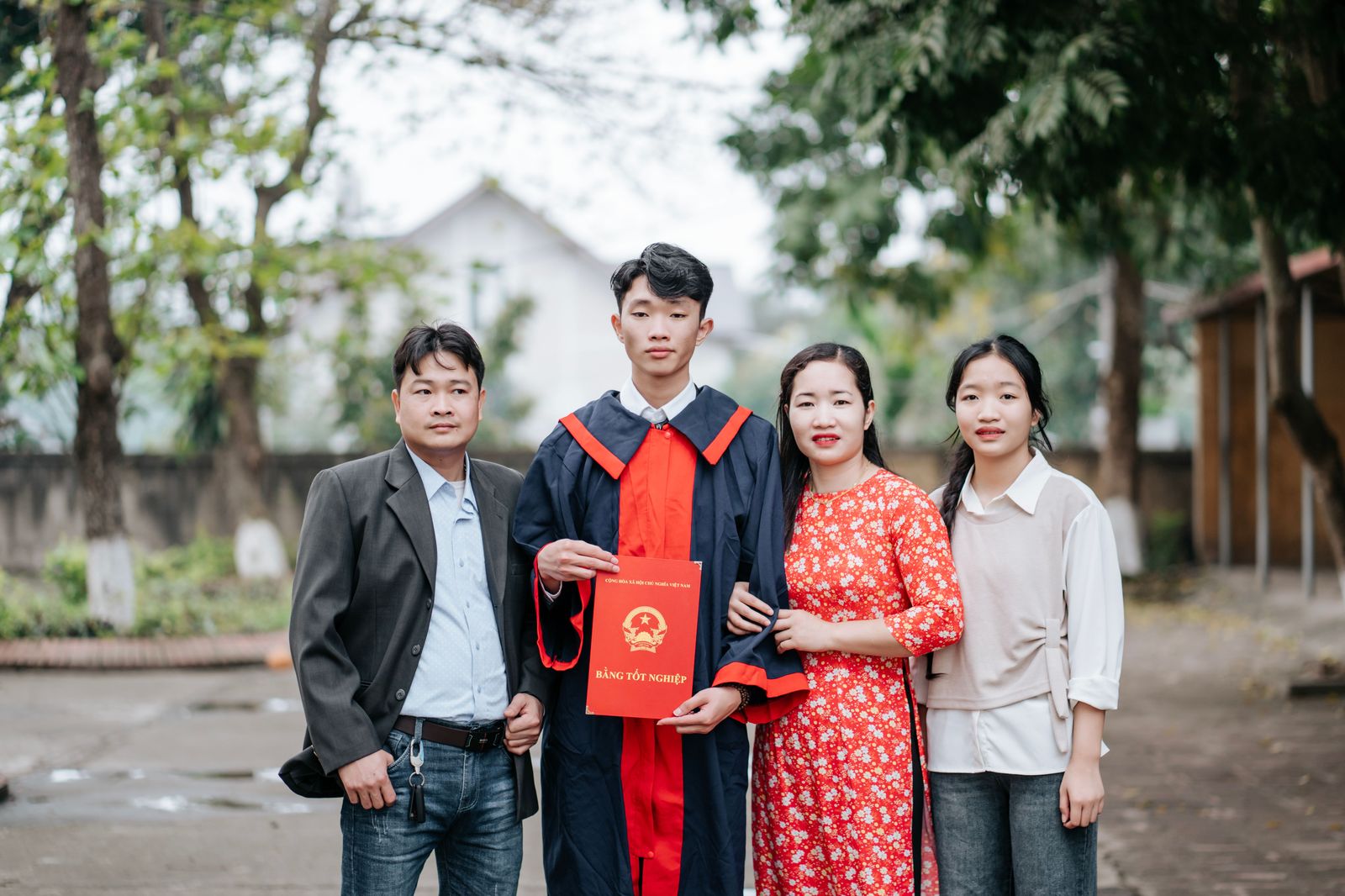 A graduate in cap and gown with parents after the ceremony
