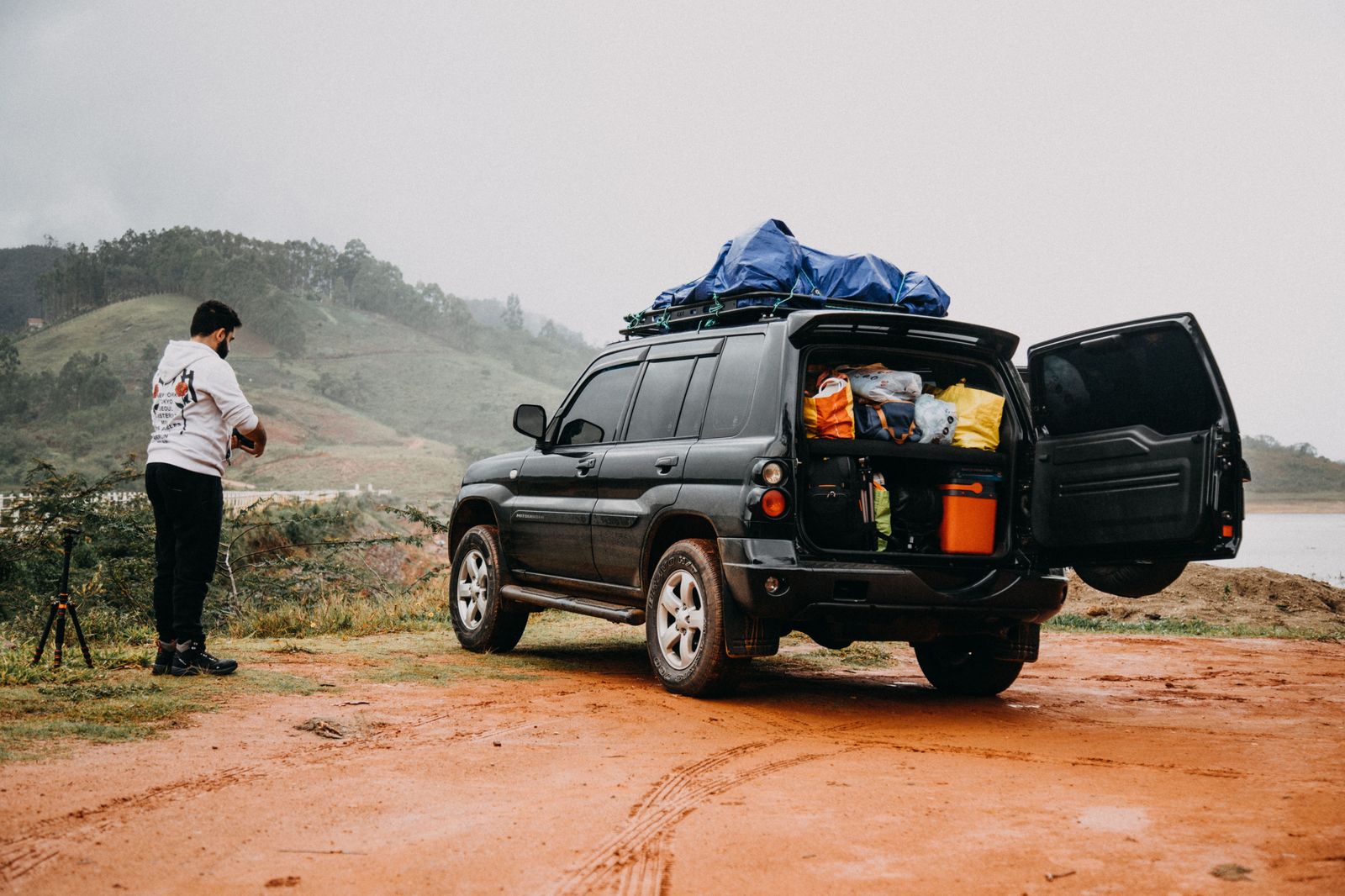 A family loading luggage into a black SUV before a road trip