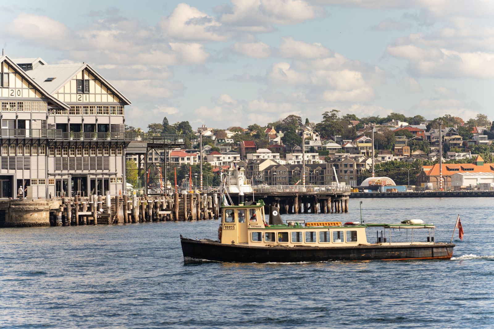 A small ferry crossing a short city harbour channel, like the crossing to the island airport