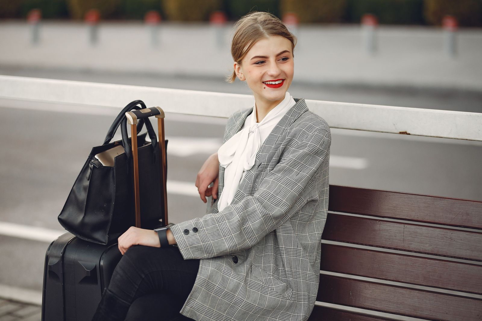 Traveller with a suitcase waiting on a bench in a terminal