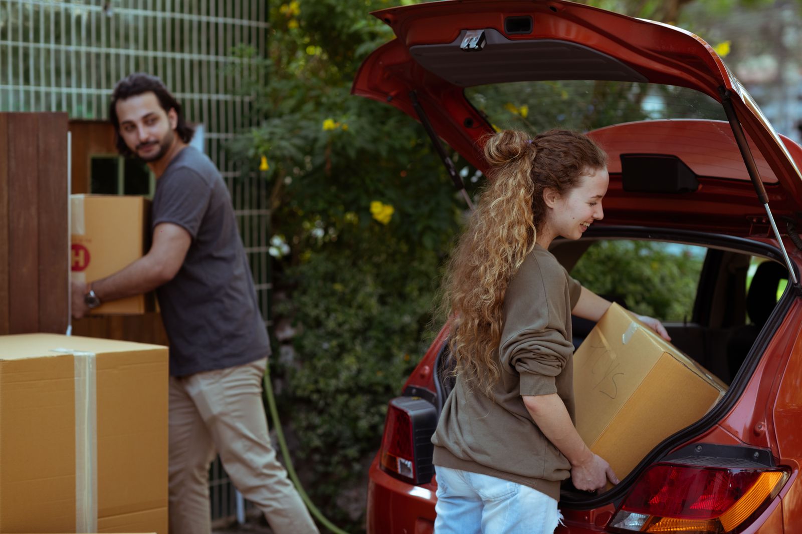 Student unloading boxes from a car at a university residence during move-in
