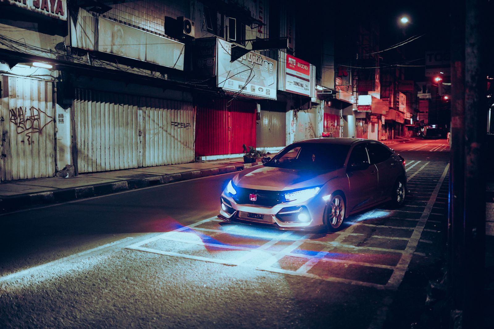 Black sedan waiting at the curb on a downtown Toronto street at night