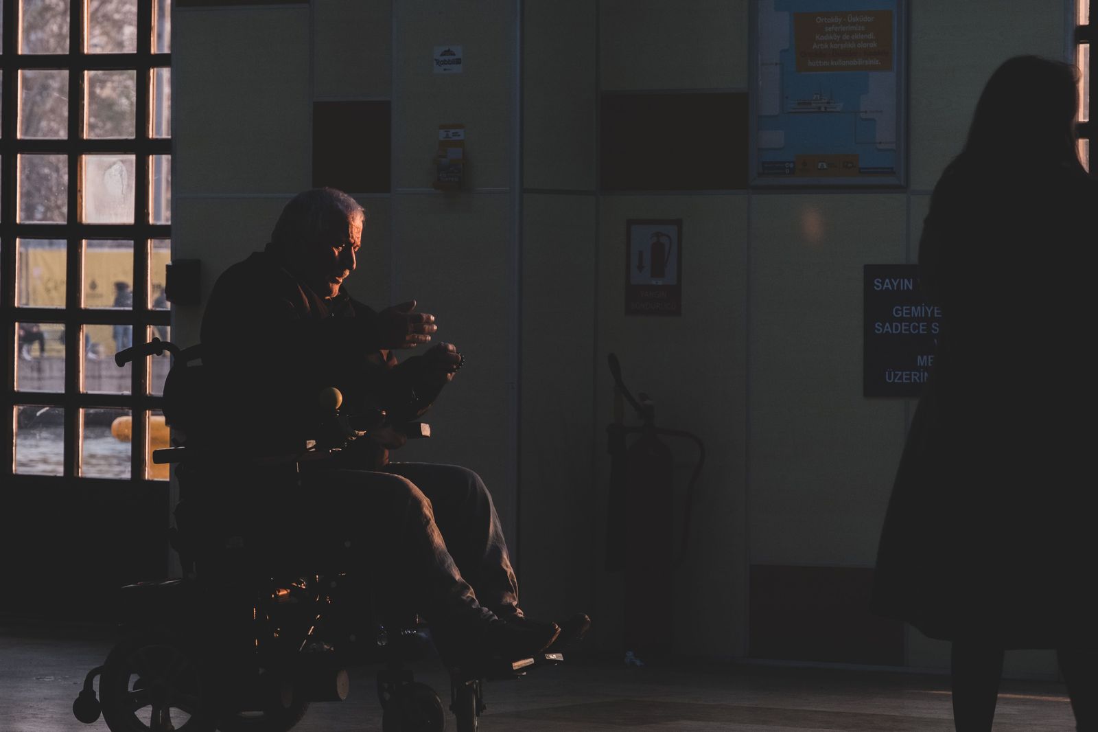 An airline wheelchair assistant with a traveller in an airport arrivals area