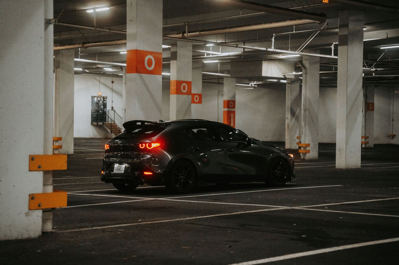 A black sedan waiting outside a venue at night on an hourly booking