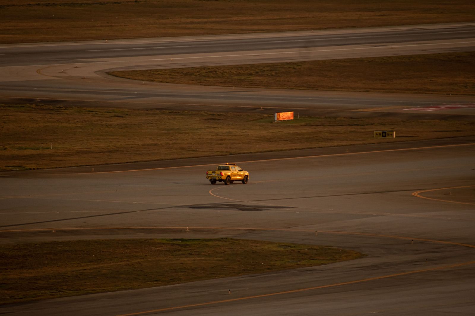 An executive SUV waiting near the runway for a private arrival