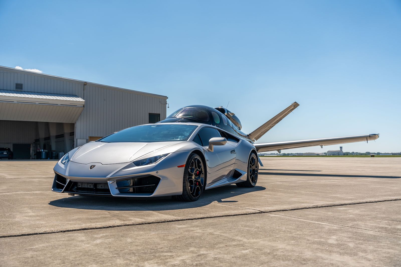 A luxury car waiting beside a private jet on the tarmac